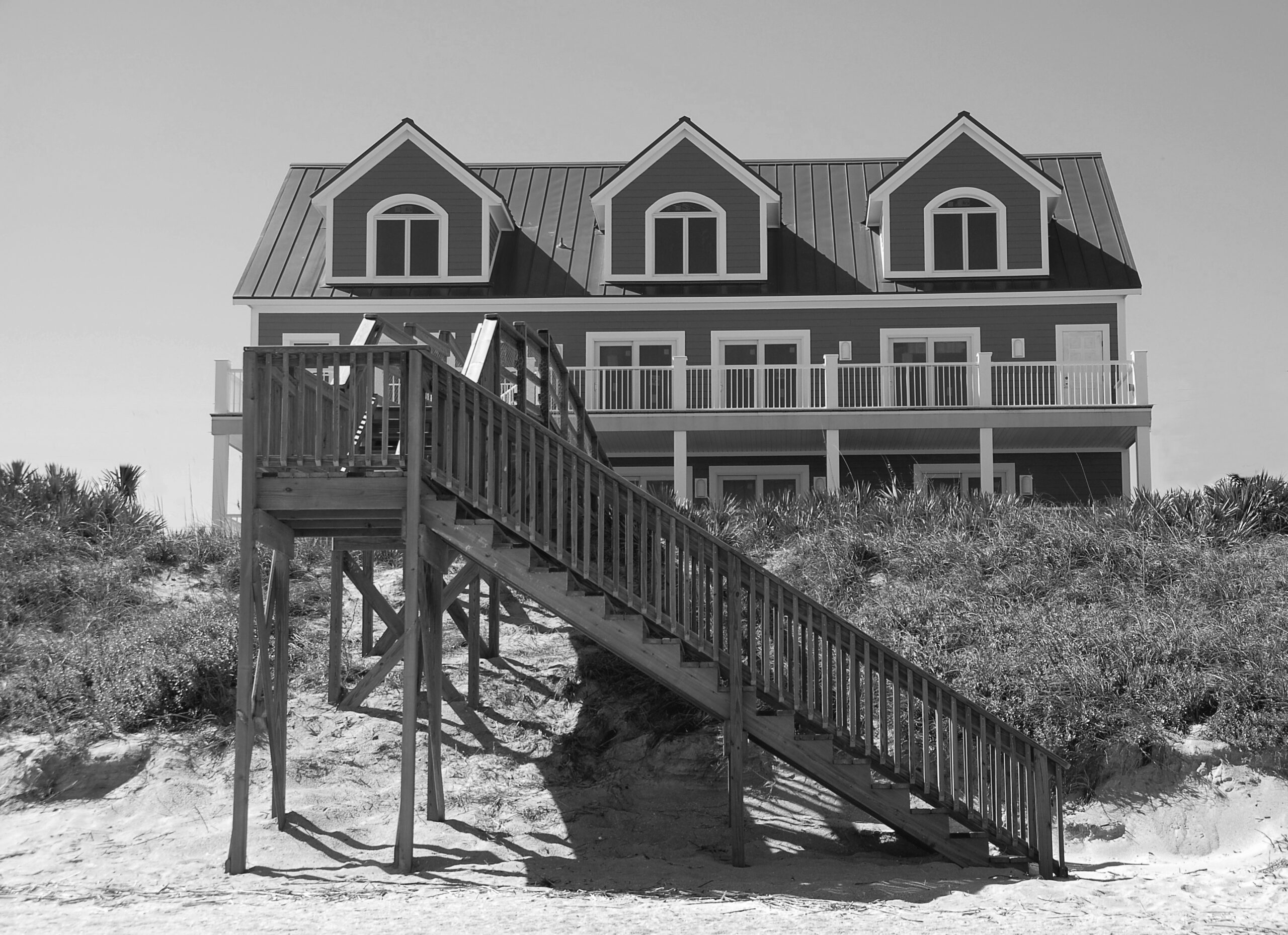 Foto van huis met een grote trap in een strandlandschap